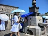 Caldo record in Europa, Oms: oltre 1.300 morti in una settimana. Allerta maltempo in 9 regioni Persone si proteggono dal caldo estremo in una piazza europea