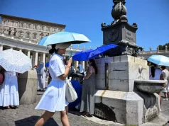 Caldo record in Europa, Oms: oltre 1.300 morti in una settimana. Allerta maltempo in 9 regioni Persone si proteggono dal caldo estremo in una piazza europea