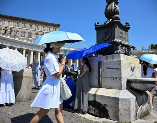 Caldo record in Europa, Oms: oltre 1.300 morti in una settimana. Allerta maltempo in 9 regioni Persone si proteggono dal caldo estremo in una piazza europea