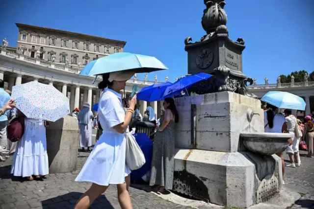 Persone si proteggono dal caldo estremo in una piazza europea