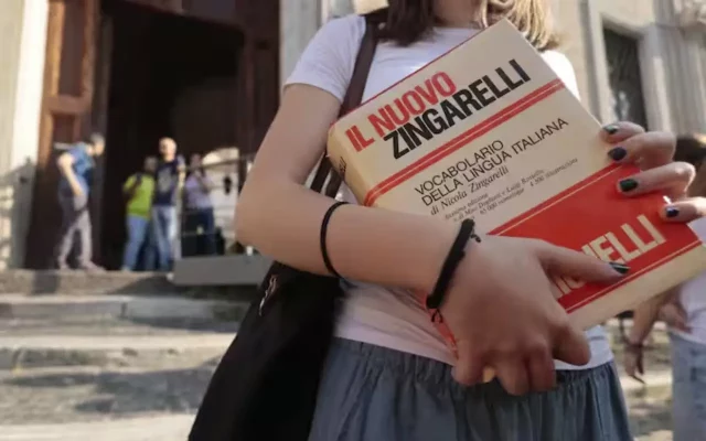 Studentessa entra a scuola con il vocabolario per la prima prova della Maturità 2026
