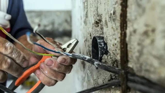 Lavori di manutenzione in giardino Uomo mentre esegue lavori su un impianto elettrico in giardino