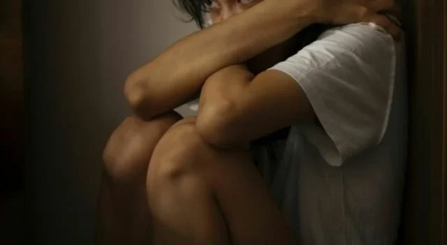 Ragazza vittima di violenza sessuale Ragazza impaurita rannicchiata a terra vittima di violenza
