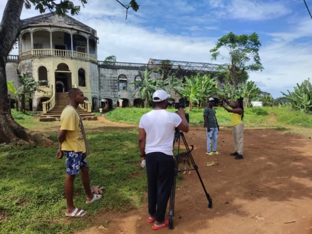 Documentario São Tomé e Príncipe, troupe cinematografica durante le riprese davanti a un edificio storico